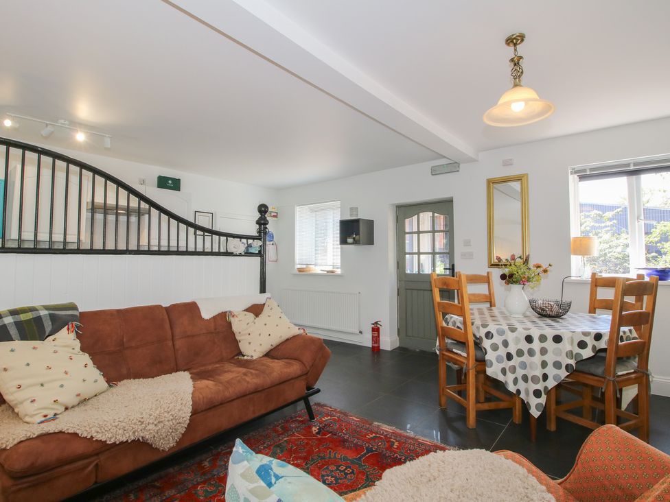 A living room with a sofa and dining table at Chess Cottage in Weobley