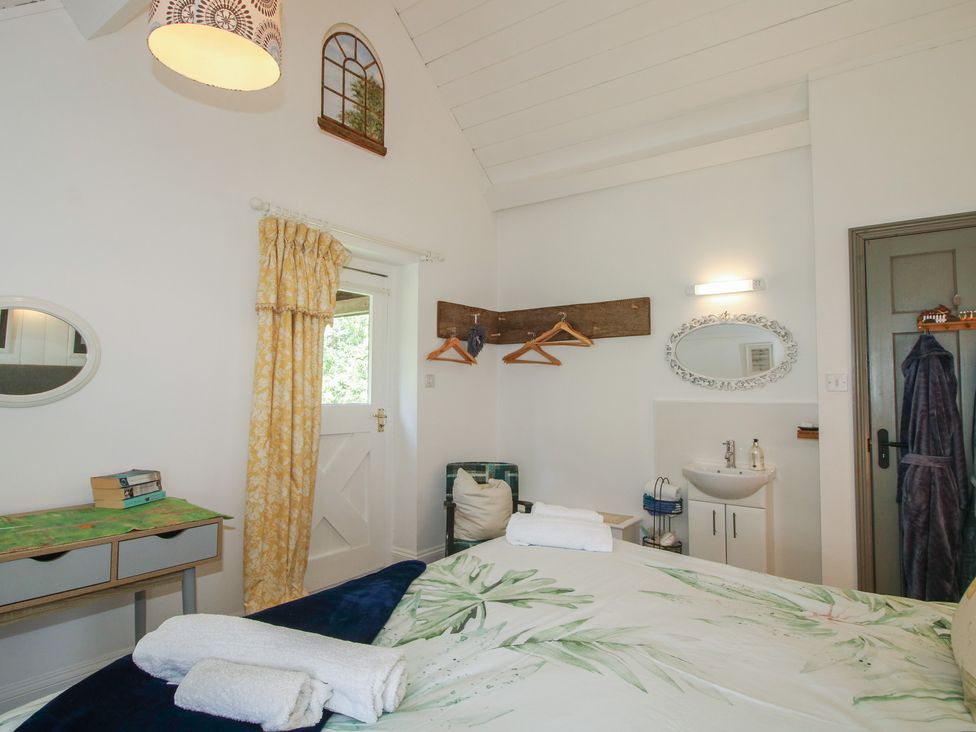 A bedroom with a bed, towels, and a sink at Chess Cottage in Weobley