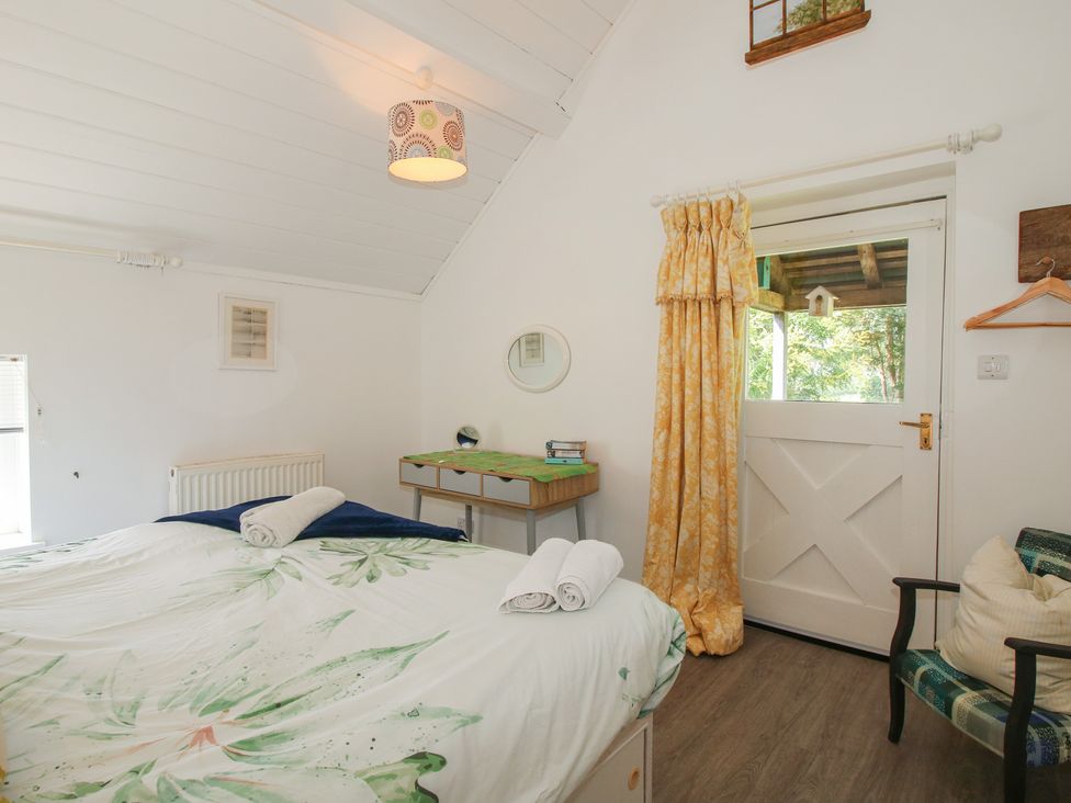 A bedroom with a bed and desk at Chess Cottage in Weobley