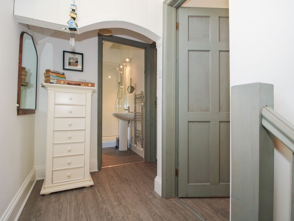 A hallway with a chest of drawers and a door to a bathroom at Chess Cottage Weobley