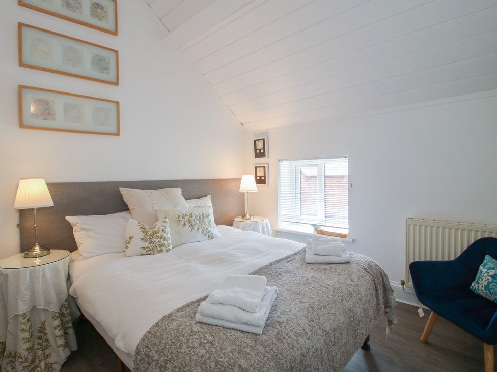A bedroom with a bed and bedside table at Chess Cottage in Weobley