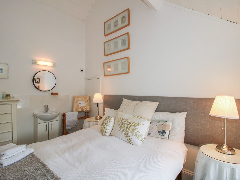 A bedroom with a bed and a sink at Chess Cottage in Weobley