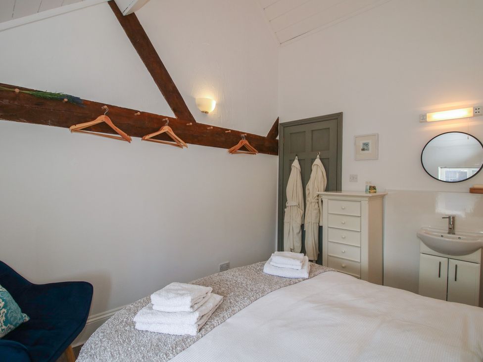 A bedroom with a bed and towels at Chess Cottage in Weobley