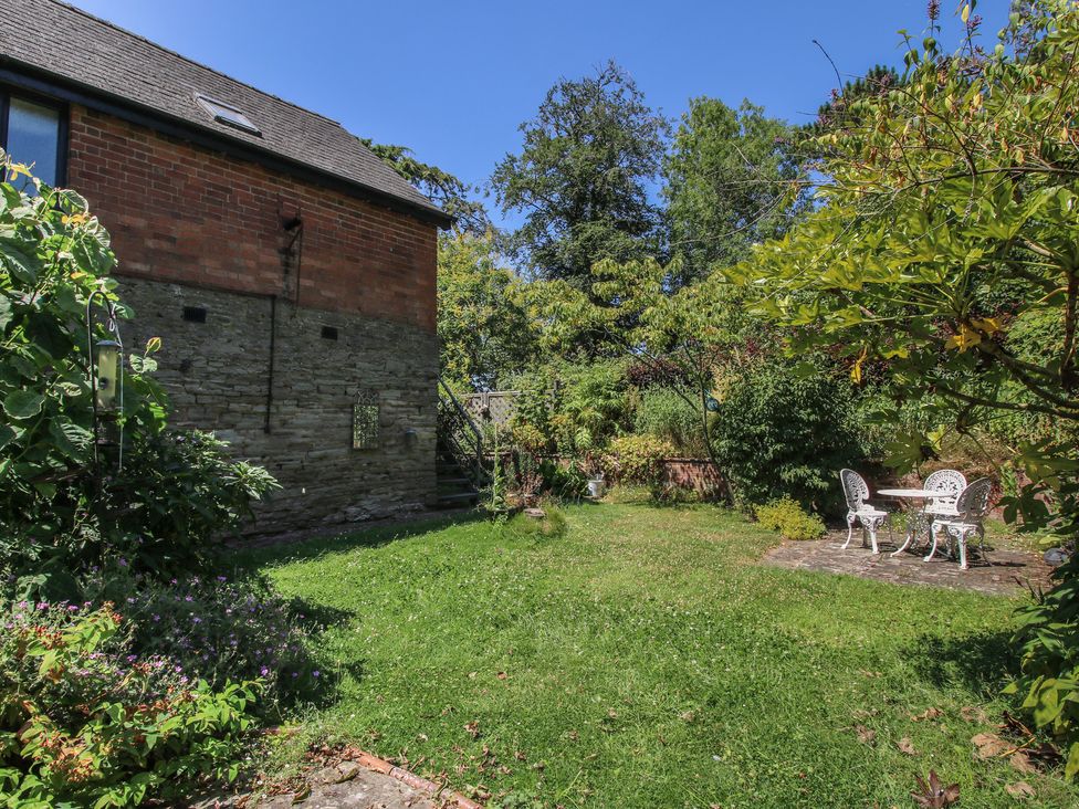 A garden with a table and chairs at Chess Cottage Weobley