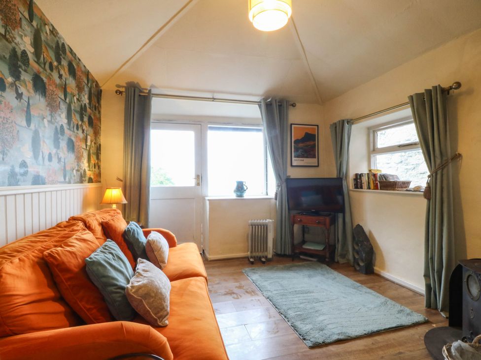 A living room with a sofa and television at Bwthyn Bach in Pentrefelin