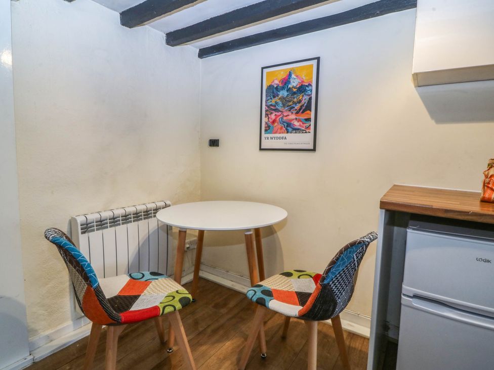 A dining area with a table and chairs at Bwthyn Bach in Pentrefelin