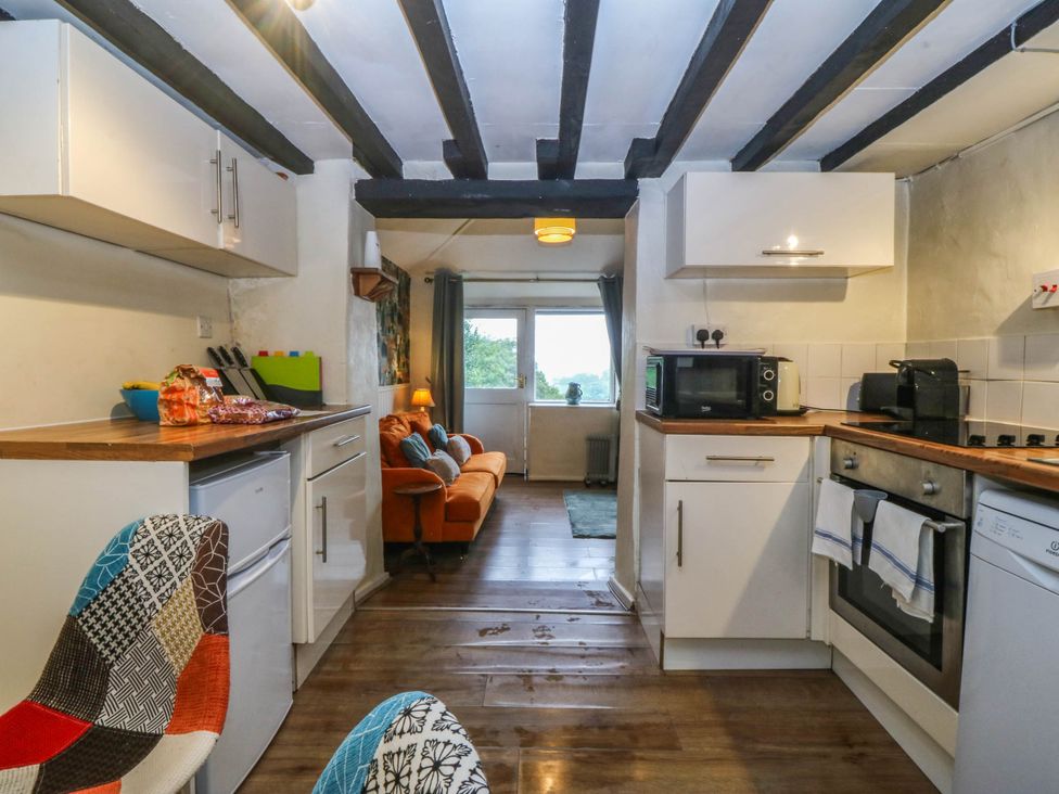 A kitchen with appliances and seating area at Bwthyn Bach in Pentrefelin