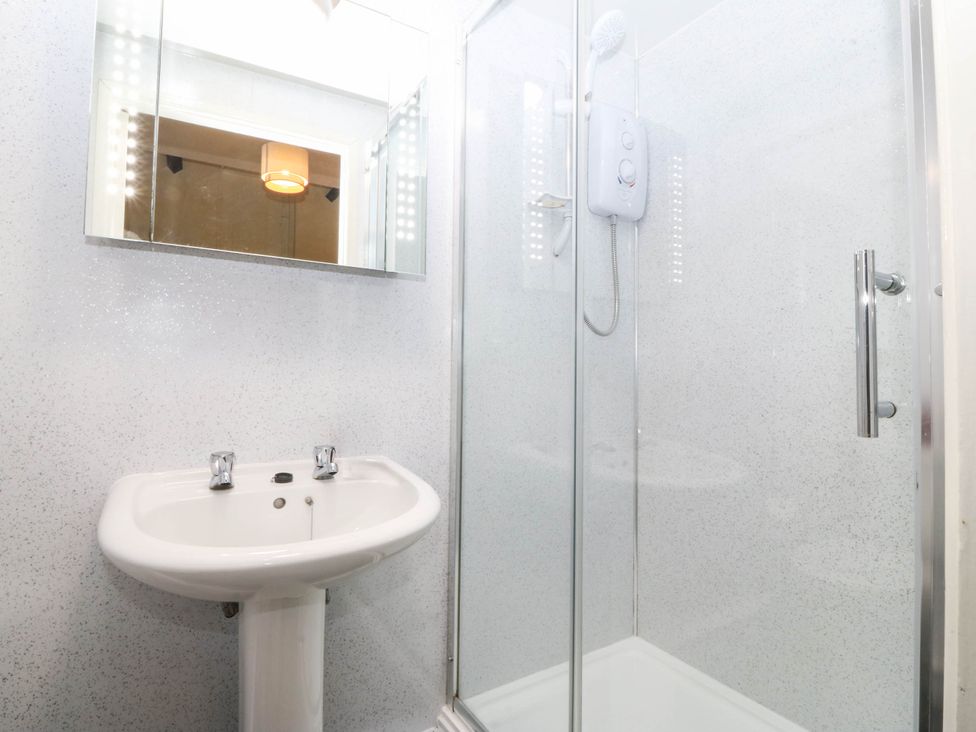 A bathroom with a sink and shower at Bwthyn Bach in Pentrefelin