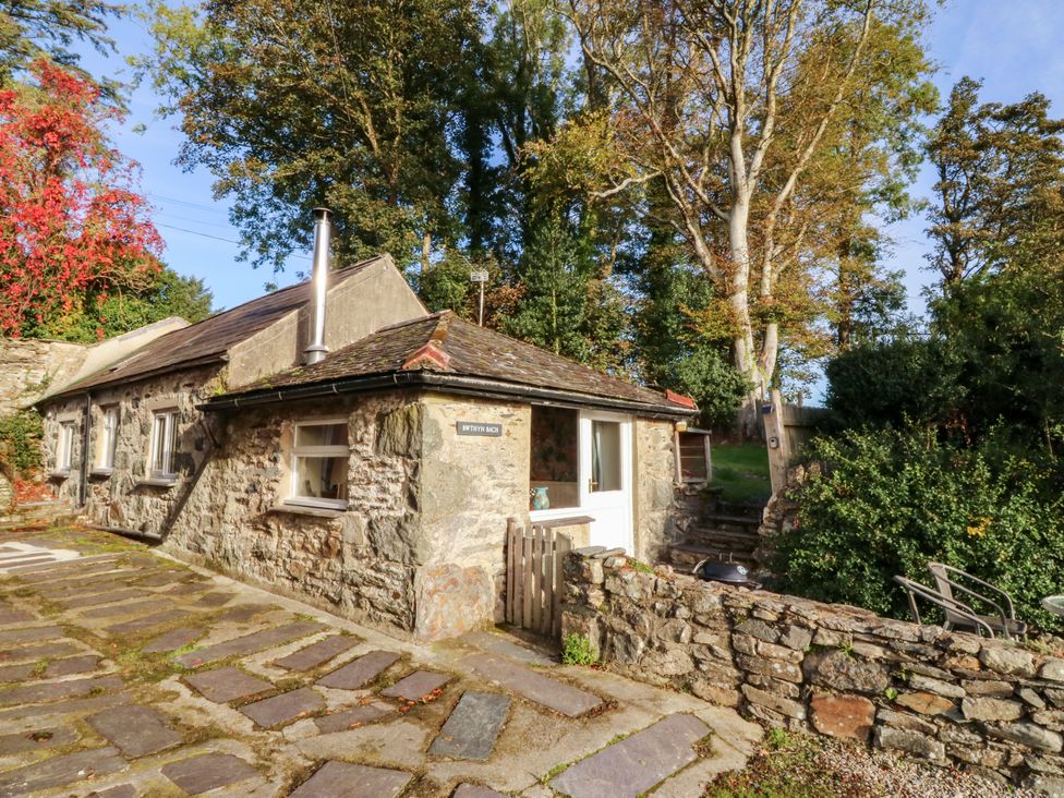A stone cottage with a pathway and garden at Bwthyn Bach in Pentrefelin
