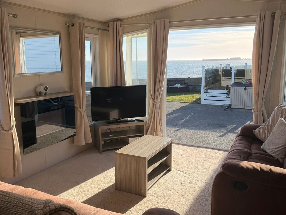 A living room with a TV and a coffee table at Trecco Bay holiday park, Porthcawl