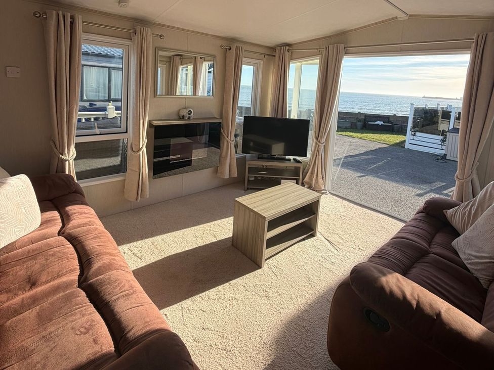 A living room with a television and coffee table at Trecco Bay holiday park, Porthcawl