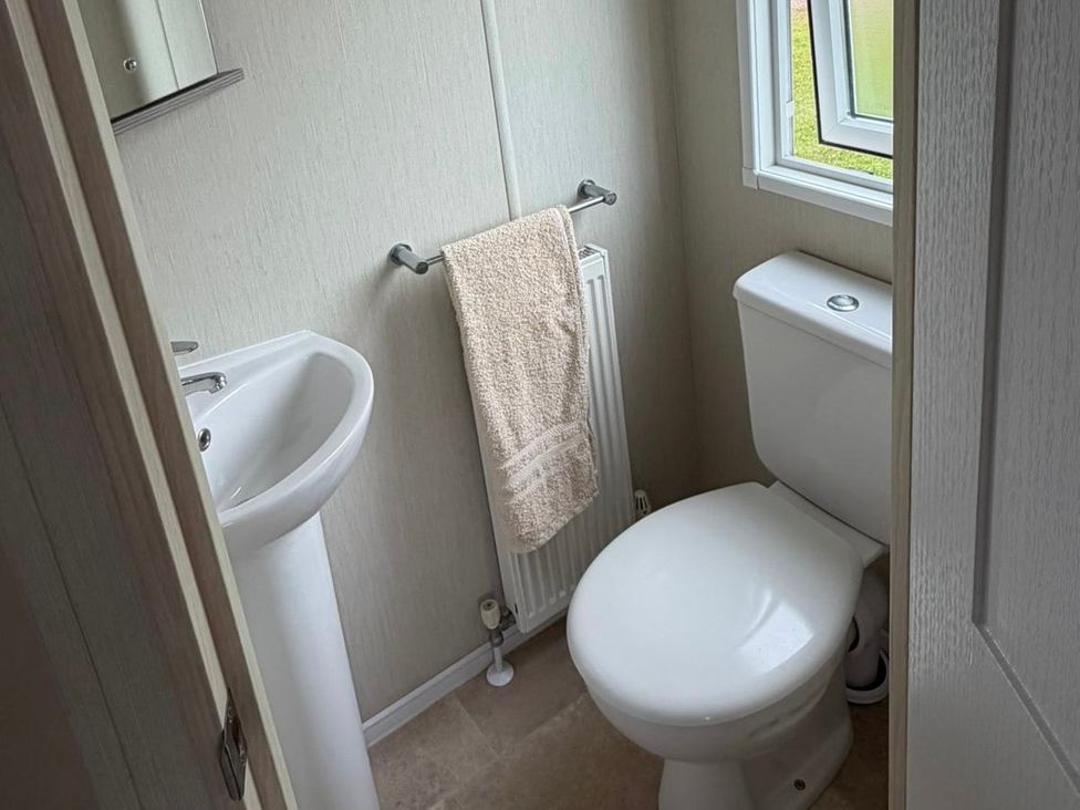 A bathroom with a sink and toilet at Trecco Bay holiday park, Porthcawl