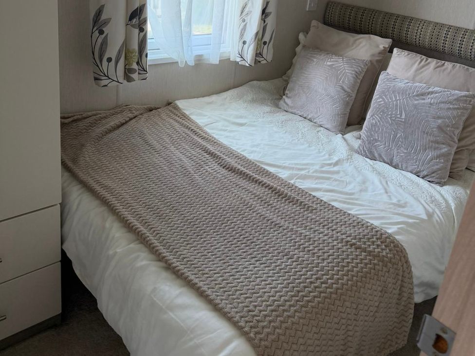 A bedroom with a bed and pillows at Trecco Bay holiday park, Porthcawl