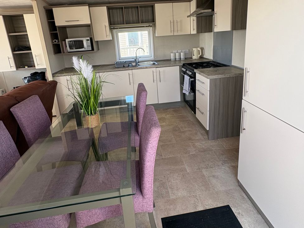 A kitchen with dining table and chairs at Trecco Bay holiday park, Porthcawl