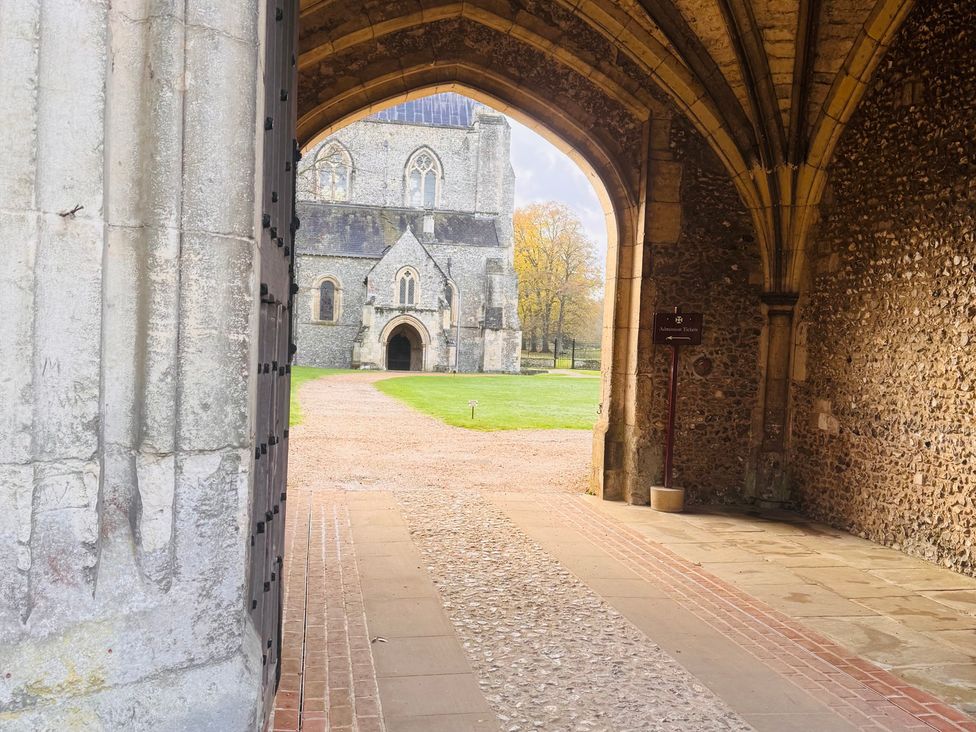 An archway leading to a building on a grassy area at The Dacha in Winchester