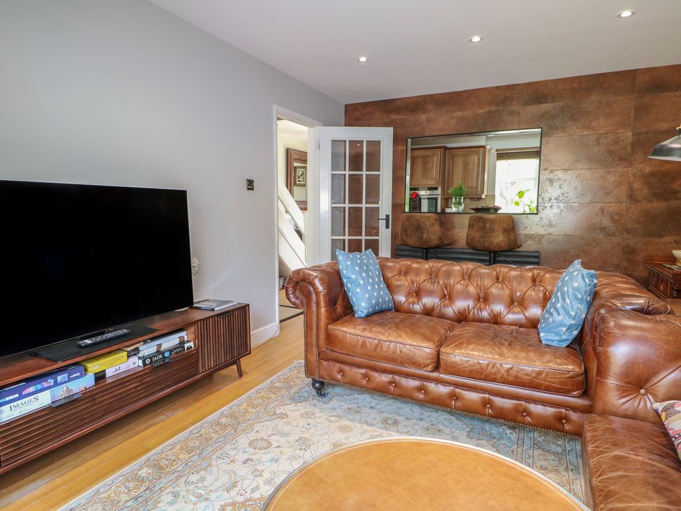 A living room with a brown sofa and television at The Dacha in Winchester