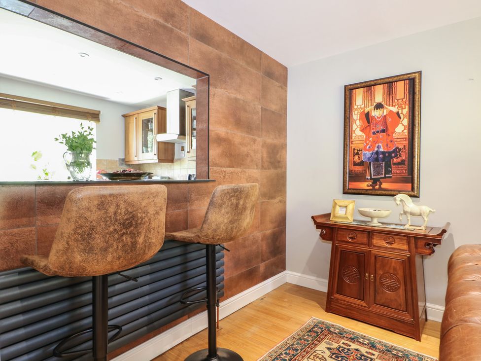 A dining room with bar stools and a console table at The Dacha in Winchester