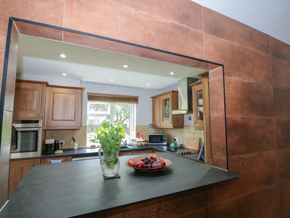 A kitchen with wooden cabinets and a counter with fruit at The Dacha in Winchester