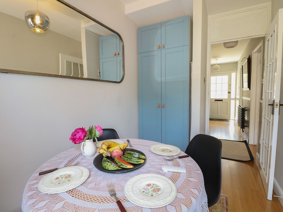 A dining room with a table set for four and a cupboard at The Dacha in Winchester