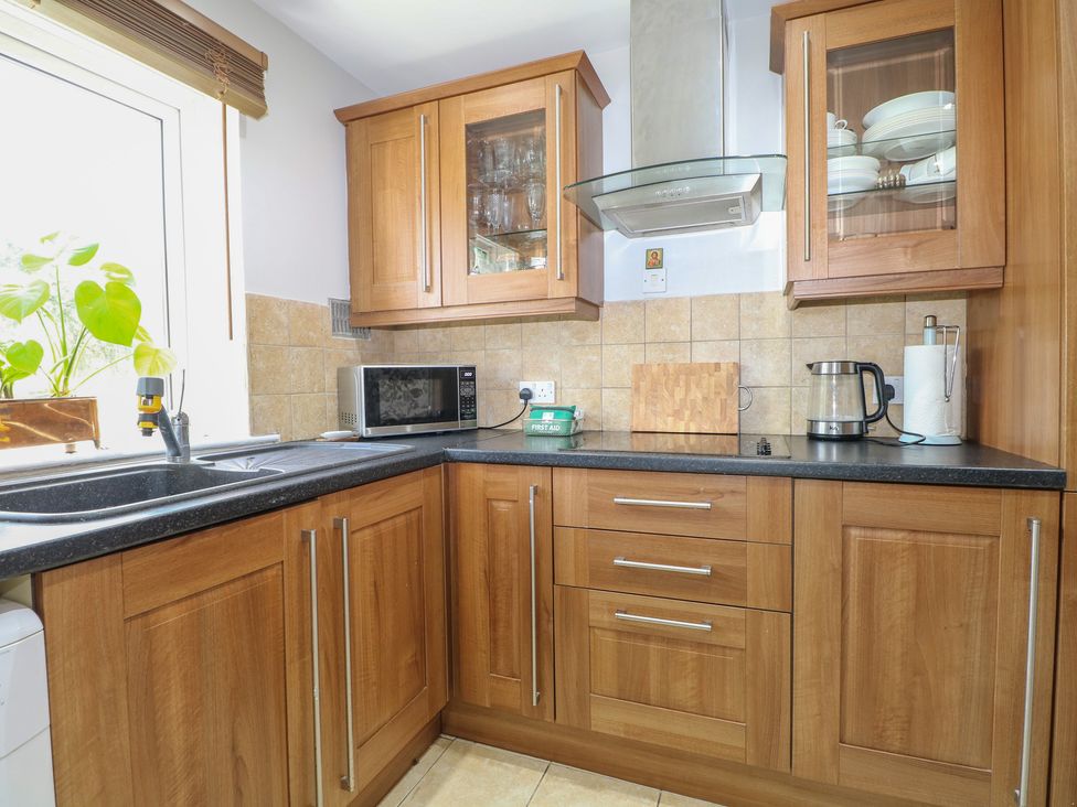 A kitchen with a sink and microwave at The Dacha in Winchester