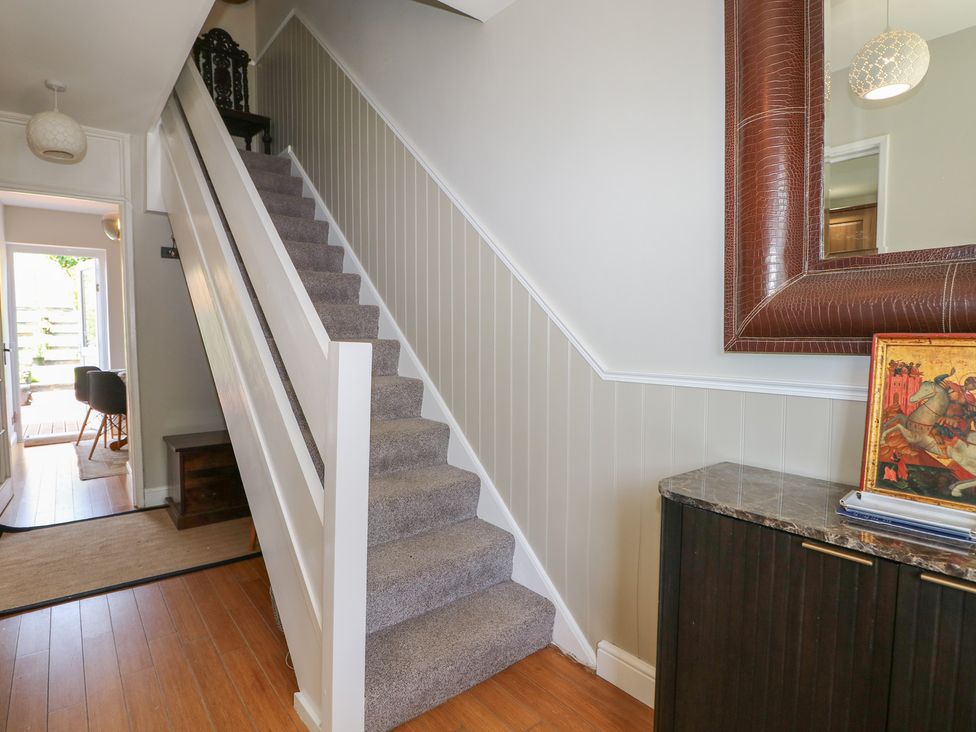 An entrance hall with a staircase and a console table at The Dacha in Winchester