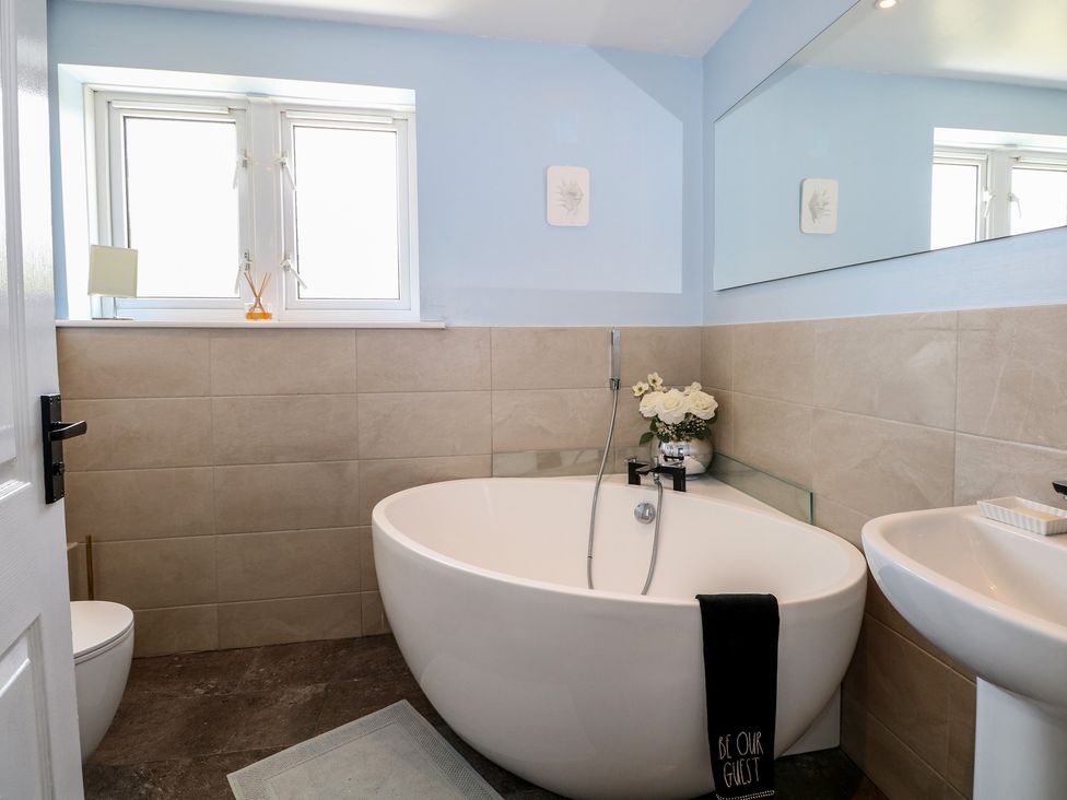 A bathroom with a bathtub and sink at The Dacha in Winchester