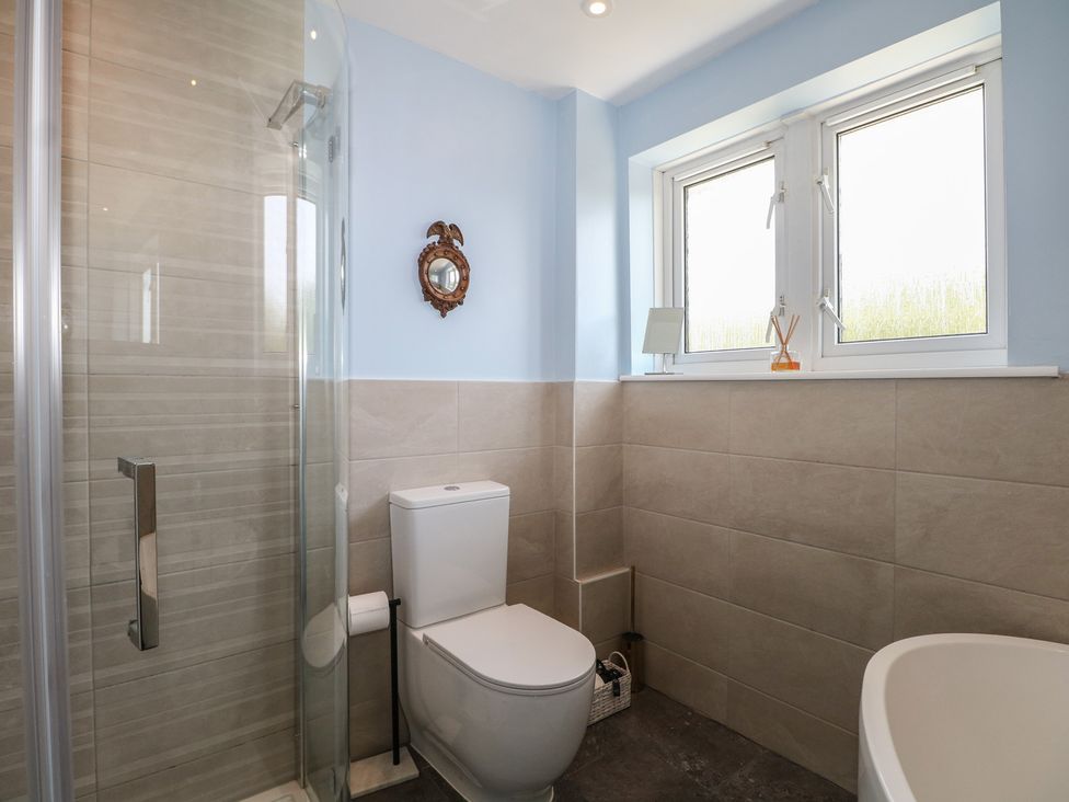 A bathroom featuring a shower, toilet, and bathtub at The Dacha in Winchester
