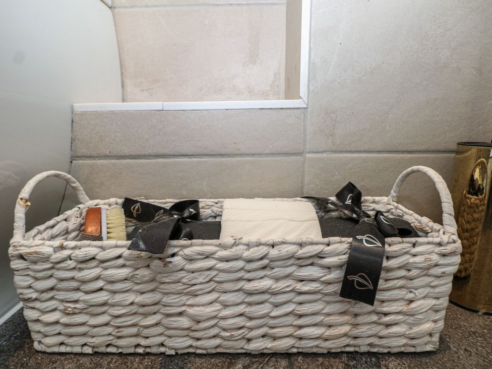 A basket containing a bottle, brush, and towel at The Dacha in Winchester