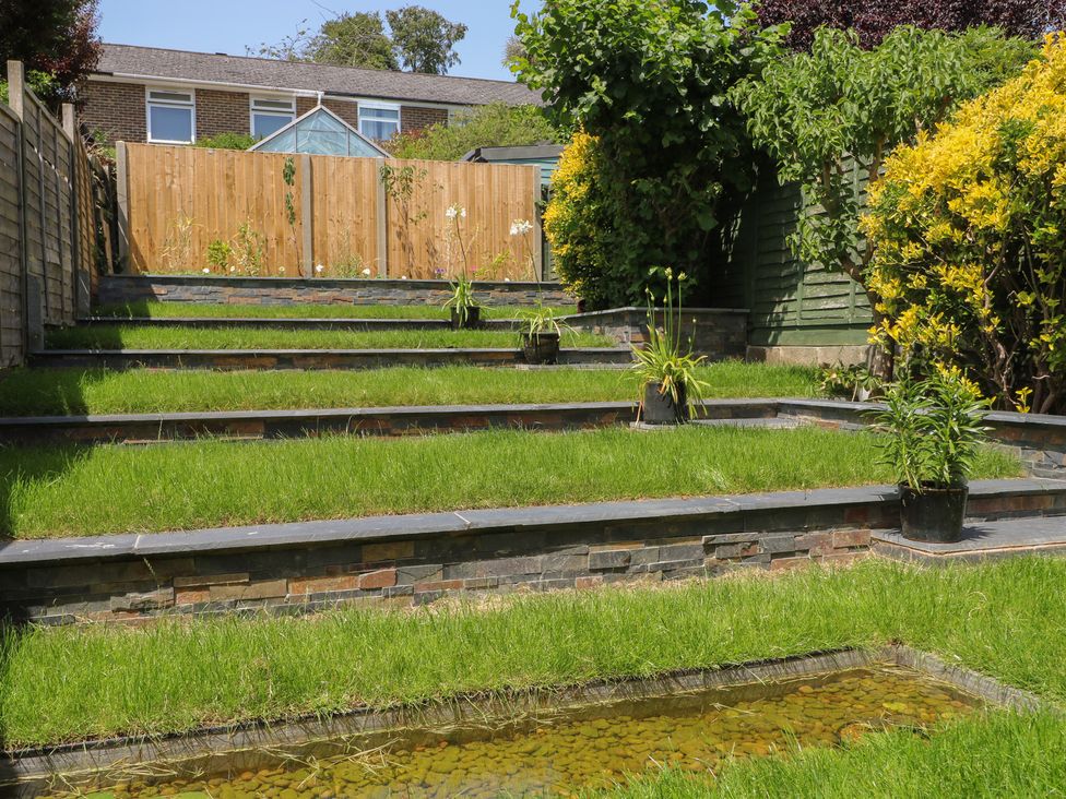 Garden with steps, planters and a pond at The Dacha in Winchester
