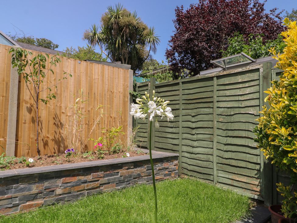 A garden with a flower and stone wall at The Dacha in Winchester