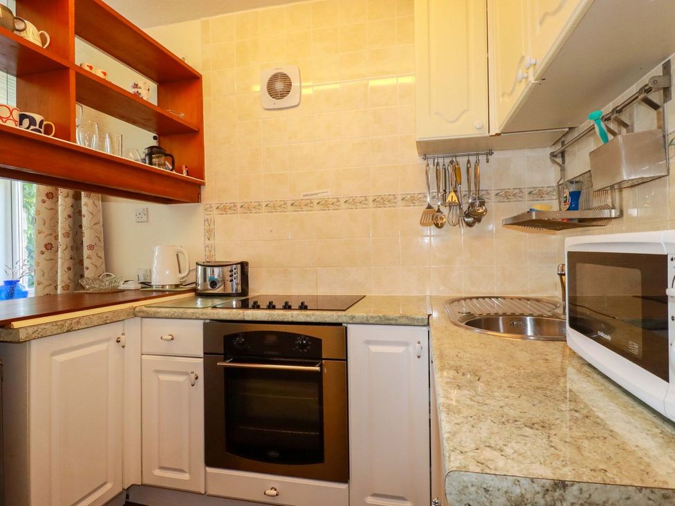 A kitchen with stove, microwave, sink, and kettle at Chyancrowse in Penzance