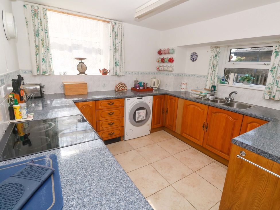 A kitchen with wooden cabinets and appliances at Chyandaunce in Penzance