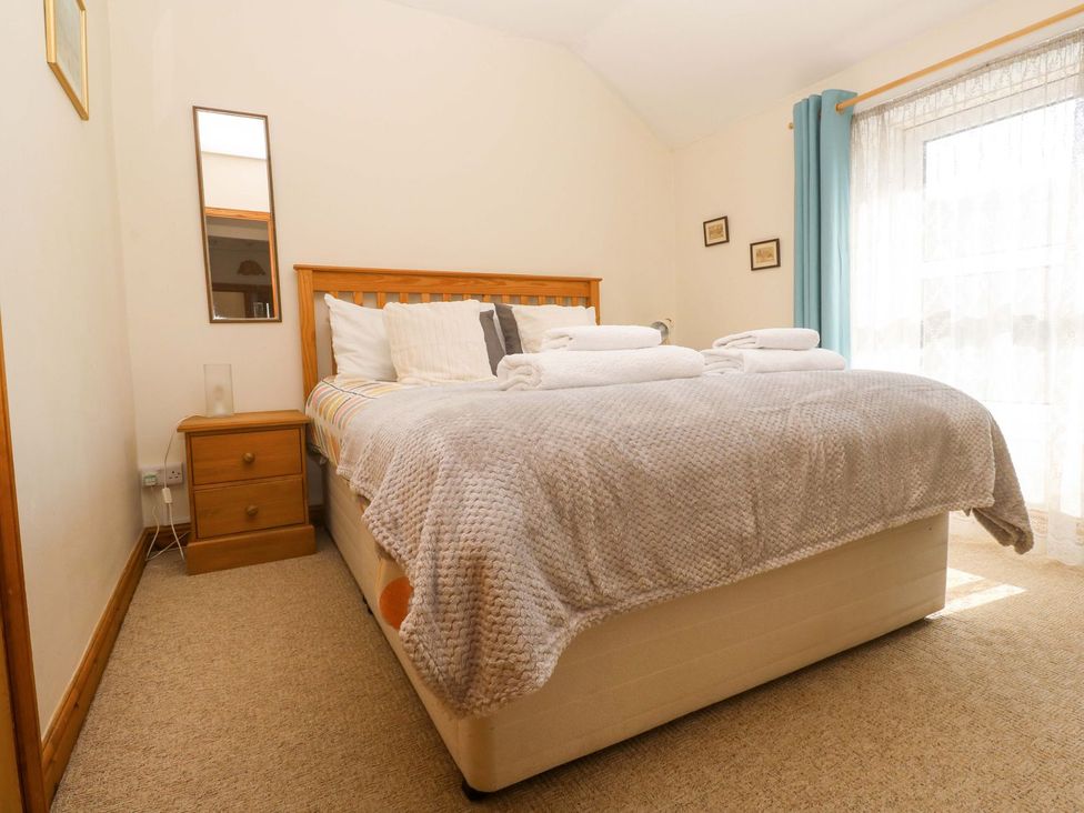 A bedroom with a bed and nightstand at Chyandaunce in Penzance