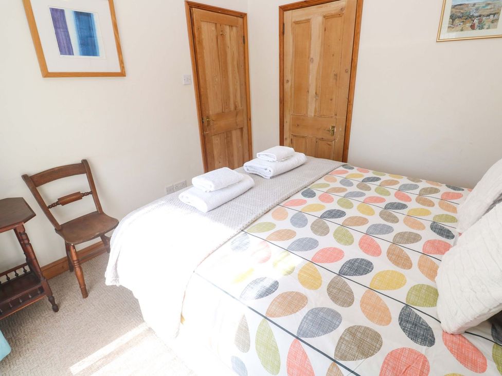 A bedroom with a bed and chairs at Chyandaunce in Penzance