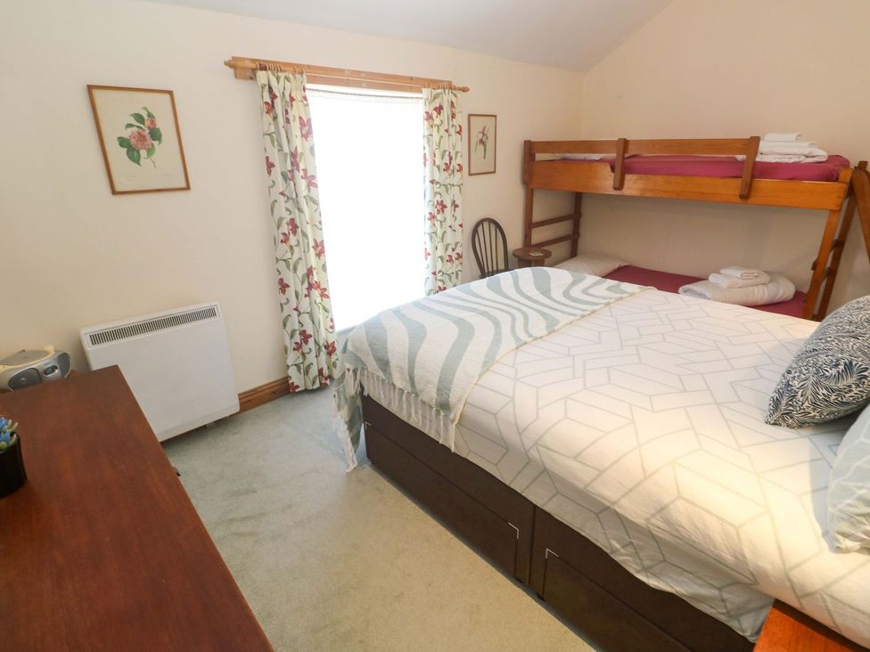 A bedroom with a double bed and a bunk bed at Chyandaunce in Penzance