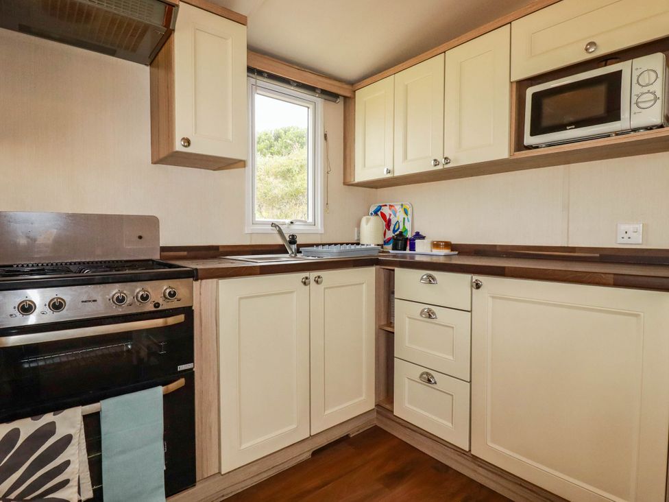 A kitchen with gas stove and sink at Roslenn in St Agnes