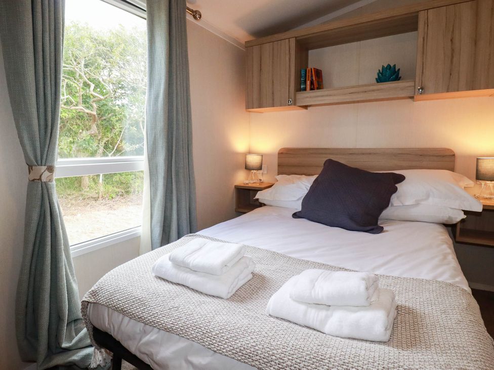 A bedroom with a bed and pillows at Roslenn in St Agnes
