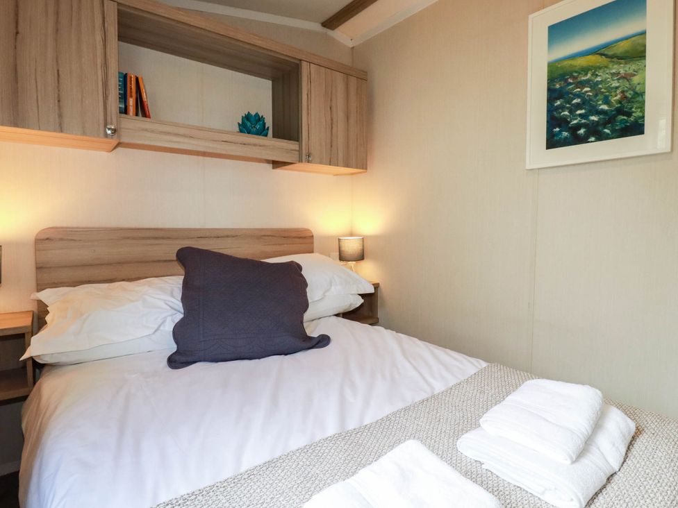 A bedroom with a bed and storage at Roslenn in St Agnes