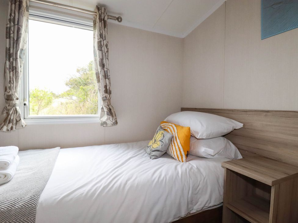 A bedroom with a bed and window at Roslenn St Agnes