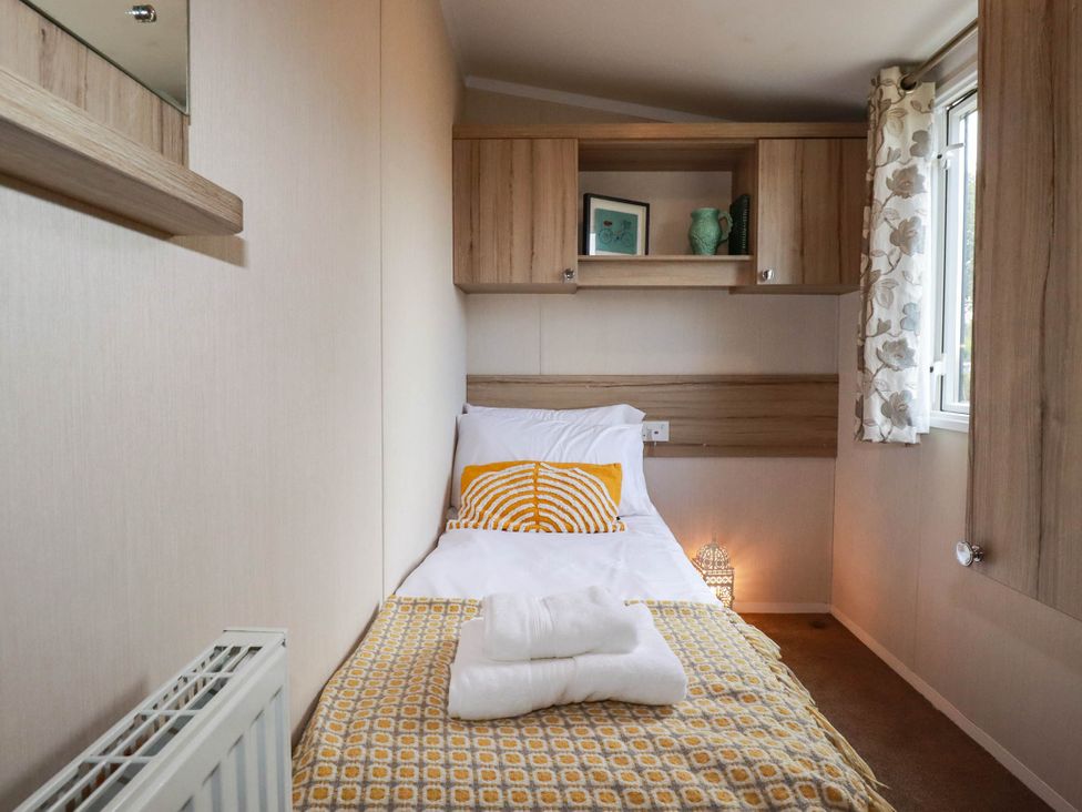 A bedroom with a bed and cabinets at Roslenn in St Agnes