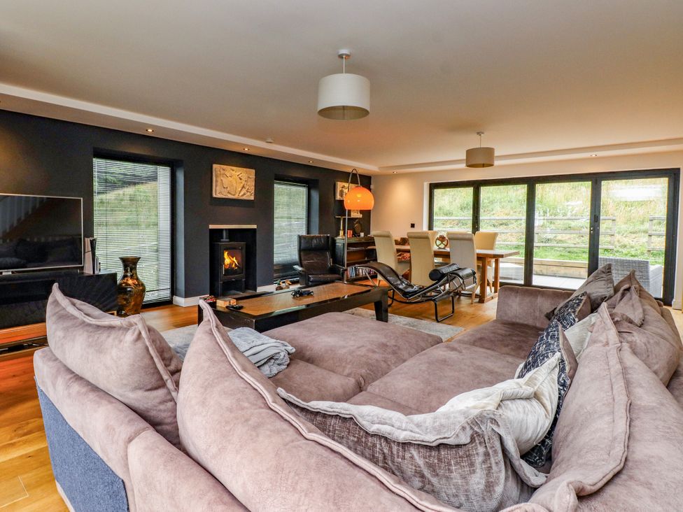 A living room with a sofa and television at The Barn at Bryn Eithin in Colwyn Bay