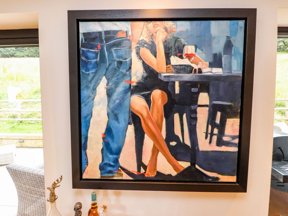 A painting of a woman at a table with a drink at The Barn at Bryn Eithin Colwyn Bay