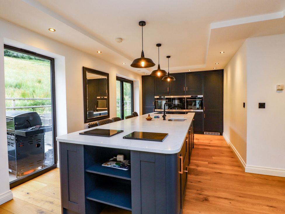 A kitchen with a large island and modern appliances at The Barn at Bryn Eithin in Colwyn Bay