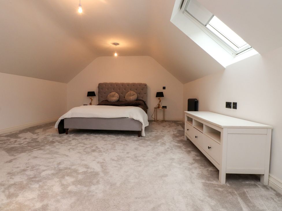 A bedroom with a bed and furnishings at The Barn at Bryn Eithin Colwyn Bay