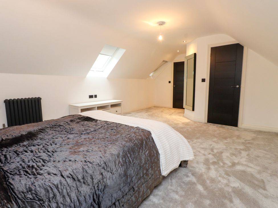 A bedroom with a bed and radiator at The Barn at Bryn Eithin Colwyn Bay