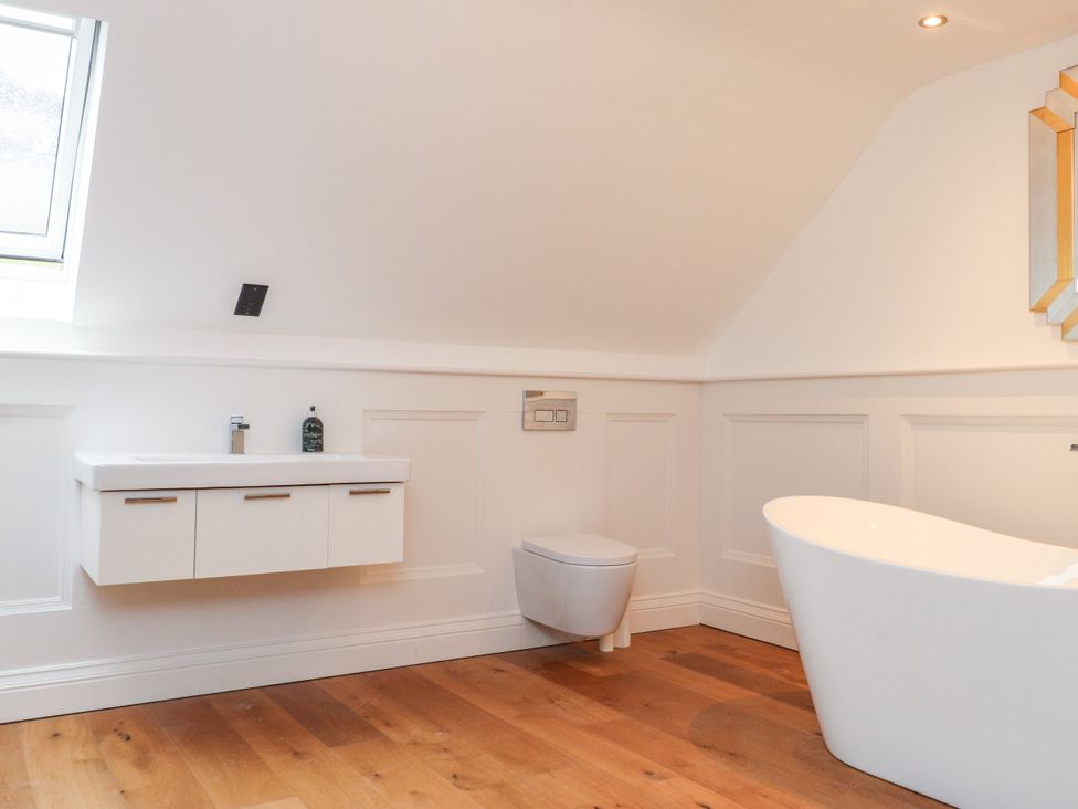 A bathroom with a bathtub and a sink at The Barn at Bryn Eithin in Colwyn Bay