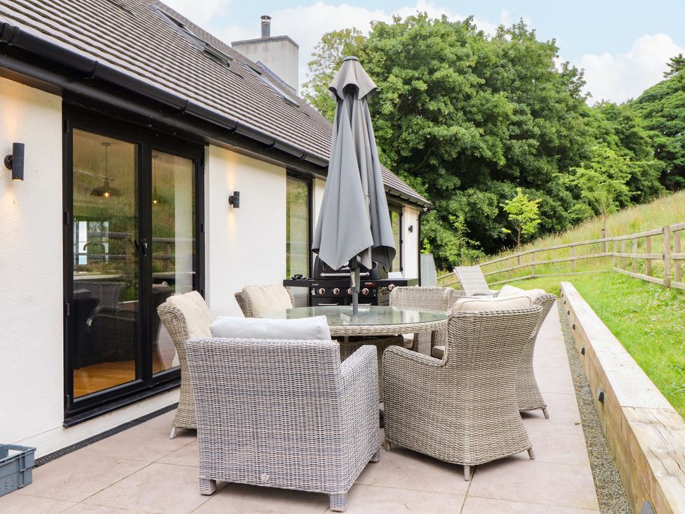 An outdoor seating area with a table and chairs at The Barn at Bryn Eithin Colwyn Bay