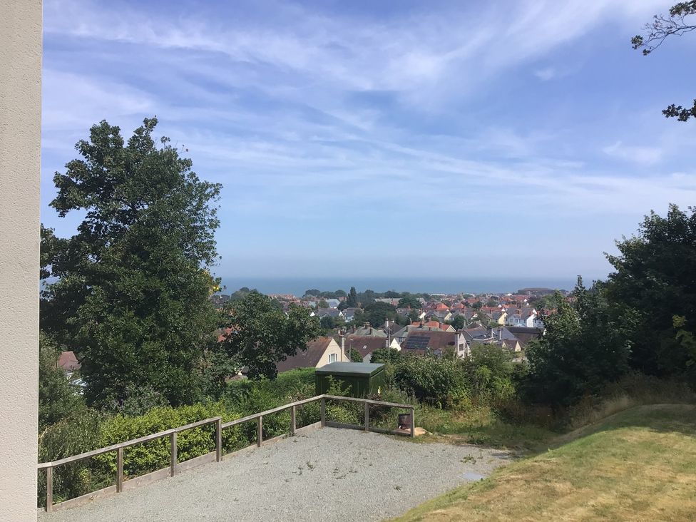 A view of the ocean and houses from a terrace at The Barn at Bryn Eithin Colwyn Bay