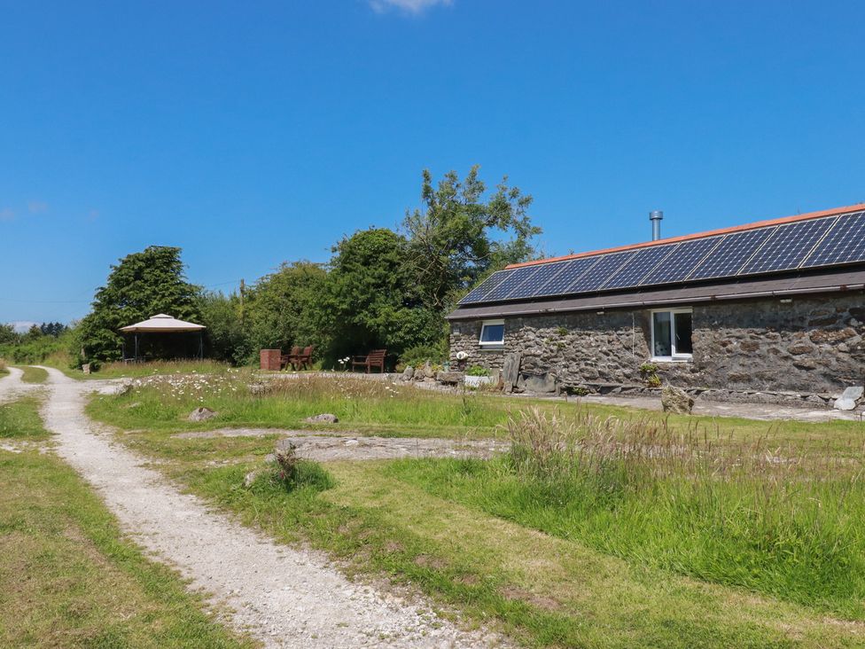 An outdoor view featuring a stone building and pathway at Moorland Retreat Bodmin