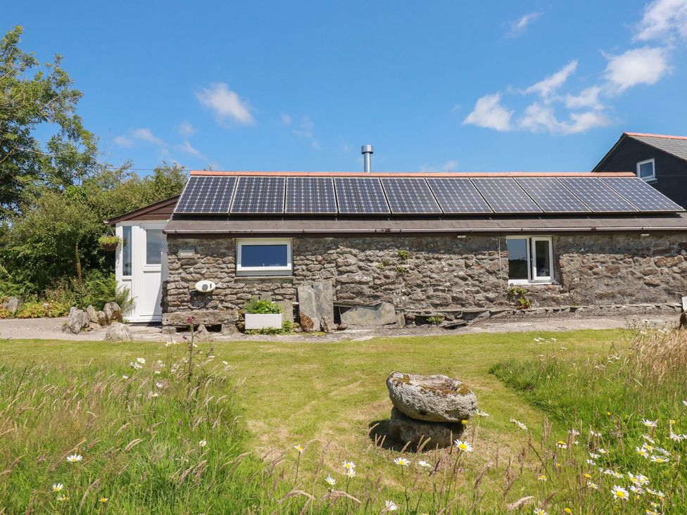 An outdoor view of a stone building with solar panels at Moorland Retreat in Bodmin